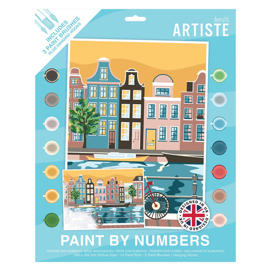 A retail package of Furiff Artiste 'Paint by Numbers' pen and brush kit, featuring a colorful illustration of Amsterdam canal houses on the front card with paint color circles and product details.